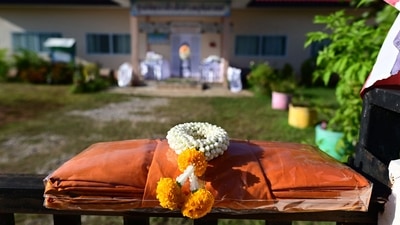 By afternoon, bouquets of white roses and carnations lined the wall outside, along with five tiny juice boxes, bags of corn chips and a stuffed animal. A faded Thai flag flew at half-staff above. (AFP) By afternoon, bouquets of white roses and carnations lined the wall outside, along with five tiny juice boxes, bags of corn chips and a stuffed animal. A faded Thai flag flew at half-staff above. (AFP)