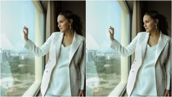 Neha decked up in a white satin top and a pair of white formal trousers. She added the necessary bling to her look with a white jacket, sequined in silver mirror work.(Instagram/@nehadhupia)