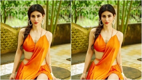 Mouni decked up in a slip orange blouse with a plunging neckline, and teamed it with a long and flowy orange satin skirt. The attire also featured a train detail from the blouse that reached the ankles.(Instagram/@imouniroy)