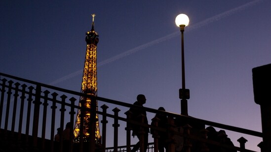 France Energy Crisis: People walk on a bridge next to the Eiffel Tower in Paris(AP)