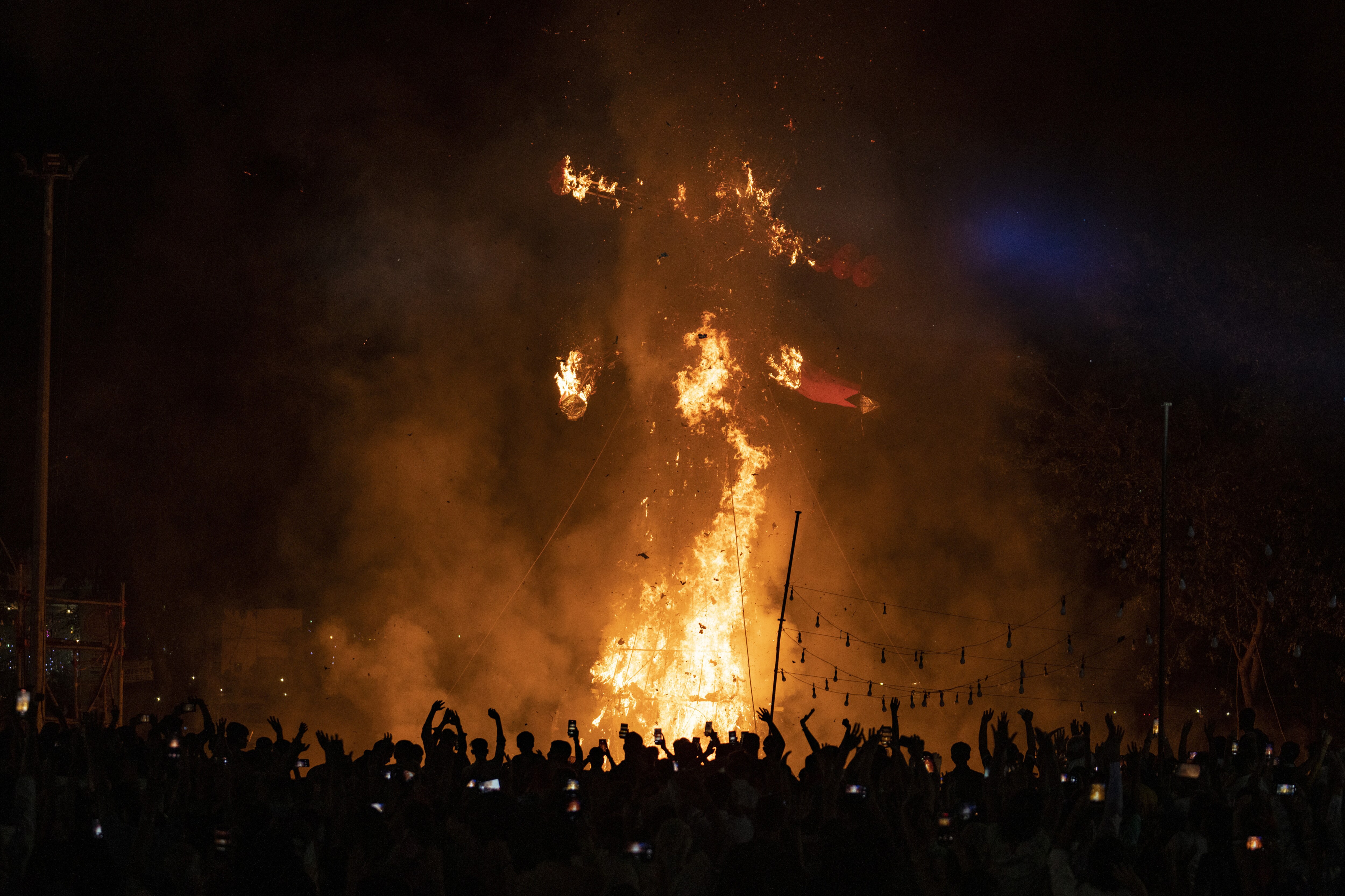 People watch the burning of effigies of demon king Ravana and his son and brother in New Delhi, India, (AP Photo/Altaf Qadri) People watch the burning of effigies of demon king Ravana and his son and brother in New Delhi, India, (AP Photo/Altaf Qadri)