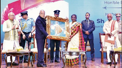 Punjab governor and UT administrator Banwarilal Purohit presenting a portrait of Guru Nanak to President Droupadi Murmu at Punjab Raj Bhawan in Chandigarh on Saturday. (HT Photo)