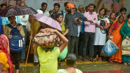 Pedestrians take shelter during rains in New Delhi on Saturday morning.(PTI)
