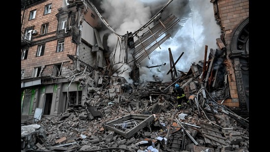 A Ukrainian firefighter pushes out a fire after a strike in Zaporizhzhia on October 6, 2022 (AFP)