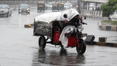 People walk down a road amid rainfall, in Gurugram on Saturday. (ANI Photo) People walk down a road amid rainfall, in Gurugram on Saturday. (ANI Photo)