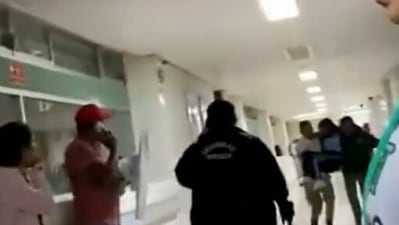 Screengrab from viral video on Twitter of a chaotic scene as parents and elders carry school children in a hospital hallway. (Twitter) Screengrab from viral video on Twitter of a chaotic scene as parents and elders carry school children in a hospital hallway. (Twitter)