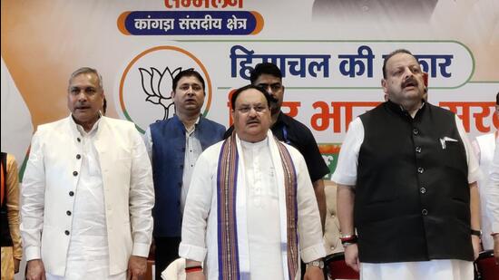 BJP national president JP Nadda (centre) along with party’s national vice-president and election in-charge for Himachal Saudan Singh (left) and his deputy Devender Singh Rana in Kangra on Sunday. (HT Photo)