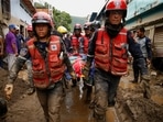 Rescue members carry the body of a person that died during a landslide, following floods due to heavy rains, in Las Tejerias, Aragua state, Venezuela October 9, 2022.&nbsp;