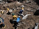 Members of a rescue team search through the rubble of destroyed houses for victims or survivors after a landslide during heavy rains in Las Tejerias, Aragua state, Venezuela, on October 10, 2022. (Photo by Yuri CORTEZ/AFP)