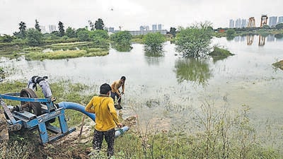 MCG workers pump out water from a temporary water body after six children who drowned on Sunday, near Shankar Vihar Colony, in Sector 111, Gurugram. (Vipin Kumar/HT Photo)