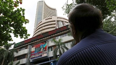 A man looks at a screen across a road displaying the Sensex on the facade of the Bombay Stock Exchange (BSE) building in Mumbai. (REUTERS)