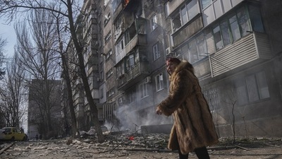 Russia-Ukraine War: A woman walks past a burning apartment building after shelling in Mariupol, Ukraine. (File image)