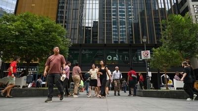 Covid In Singapore: Office workers walk out for a lunch break at Raffles Place financial business district in Singapore. (AFP) Covid In Singapore: Office workers walk out for a lunch break at Raffles Place financial business district in Singapore. (AFP)