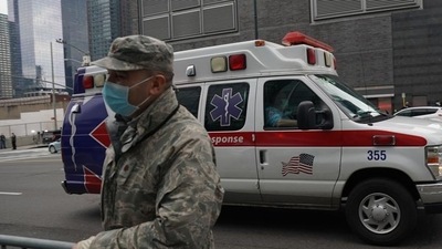 US Military: An ambulance drives by a US Army National Guards member. (AFP) US Military: An ambulance drives by a US Army National Guards member. (AFP)