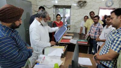 Haryana home minister Anil Vij reading through record files during a surprise inspection at the civic body office in Sadar Bazar, Ambala Cantt. (HT Photo)