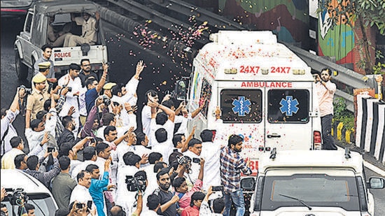 SP workers shower flowers on the ambulance carrying the body of Mulayam Singh Yadav on Monday. (HT/Sunil Ghosh)