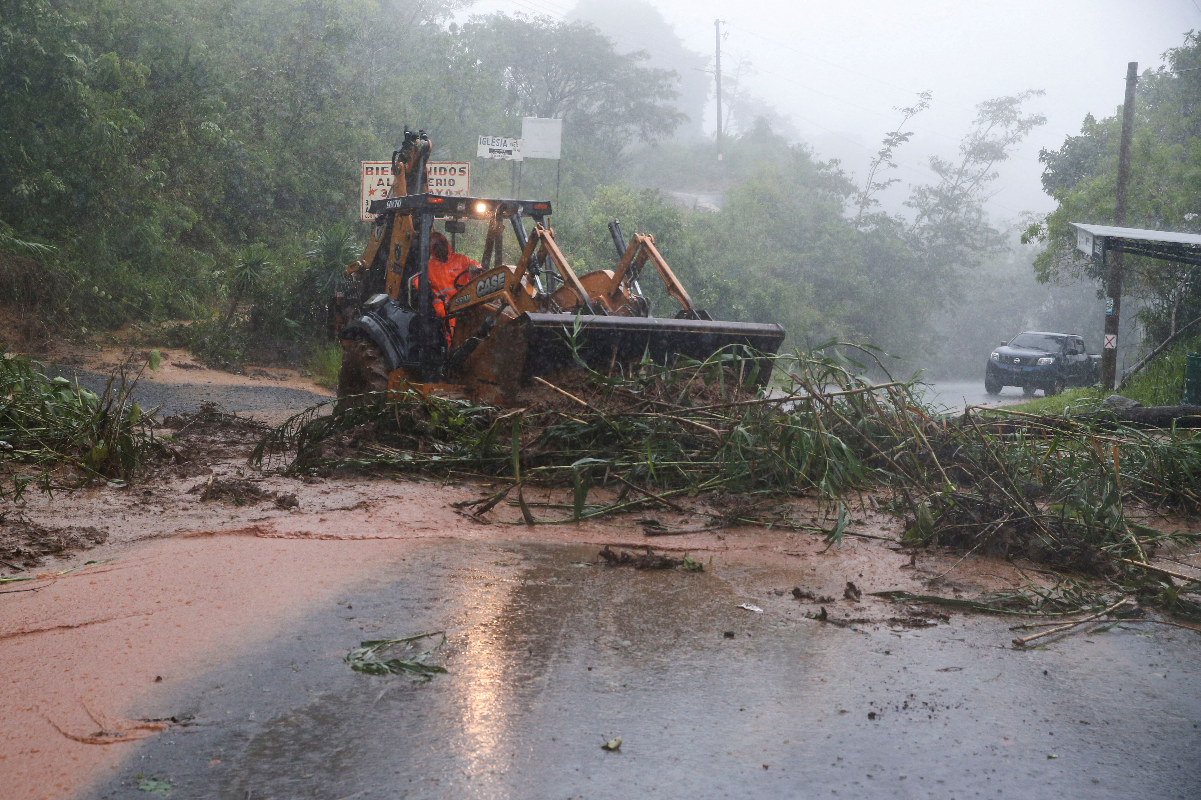 A tractor cleans a landslide near the scene where soldiers were killed in a landslide during the impact of the Tropical Storm Julia that hit with wind and rain, in Comasagua, El Salvador, October 10, 2022. (REUTERS/Jose Cabezas)