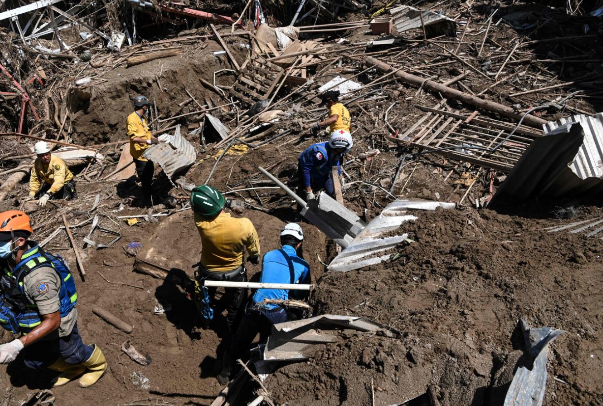 Members of a rescue team search through the rubble of destroyed houses for victims or survivors after a landslide during heavy rains in Las Tejerias, Aragua state, Venezuela, on October 10, 2022. (Photo by Yuri CORTEZ/AFP)