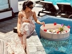 Rashmika Mandanna wore printed cut-out gown in a pretty off-white shade with black sunglasses as she posted this poolside picture from her resort. Rashmika Mandanna wore printed cut-out gown in a pretty off-white shade with black sunglasses as she posted this poolside picture from her resort.
