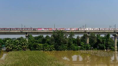 New Delhi: A metro train run on its tracks above a field flooded by the Yamuna river, in New Delhi, Thursday, Sept. 29, 2022. The water level in Yamuna in Delhi has receded slightly but it is still above the danger mark of 205.33 metres and the affected people will have to wait for a few more days before they can return to their houses in low-lying areas along the river(PTI Photo/Kamal Kishore) (PTI09_29_2022_000057A) (PTI) New Delhi: A metro train run on its tracks above a field flooded by the Yamuna river, in New Delhi, Thursday, Sept. 29, 2022. The water level in Yamuna in Delhi has receded slightly but it is still above the danger mark of 205.33 metres and the affected people will have to wait for a few more days before they can return to their houses in low-lying areas along the river(PTI Photo/Kamal Kishore) (PTI09_29_2022_000057A) (PTI)
