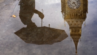 Britain Unemployment: A woman with an umbrella and the Elizabeth Tower also known as Big Ben are reflected in a puddle in London. (AP) Britain Unemployment: A woman with an umbrella and the Elizabeth Tower also known as Big Ben are reflected in a puddle in London. (AP)