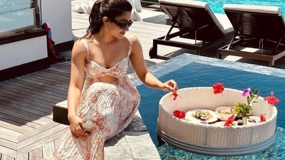 Rashmika Mandanna wore printed cut-out gown in a pretty off-white shade with black sunglasses as she posted this poolside picture from her resort. Rashmika Mandanna wore printed cut-out gown in a pretty off-white shade with black sunglasses as she posted this poolside picture from her resort.