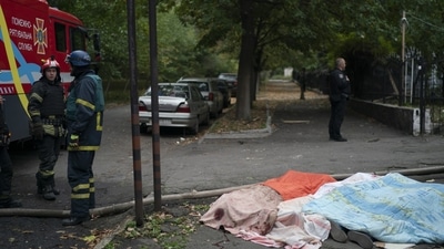 Russia-Ukraine War: Firefighters stand next to three bodies, covered by blankets, following a Russian attack in Dnipro, Ukraine. (AP) Russia-Ukraine War: Firefighters stand next to three bodies, covered by blankets, following a Russian attack in Dnipro, Ukraine. (AP)