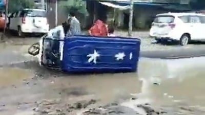 An e-rickshaw topples in UP's Sitapur due to potholes. Convoy of officials pass by it but do not stop, shows a viral video. (Twitter) An e-rickshaw topples in UP's Sitapur due to potholes. Convoy of officials pass by it but do not stop, shows a viral video. (Twitter)