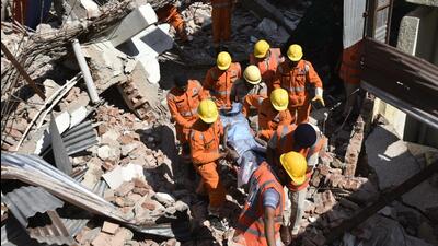 NDRF and SDRF personnel take a labourer’s body out of the rubble during a rescue operation after an old building collapsed while it was being demolished, at Udyog Vihar Phase I, in Gurugram, on October 3. (Hindustan Times)