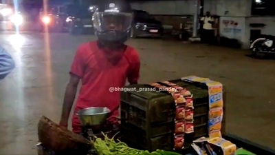 The image shows the vegetable vendor wearing a helmet while pushing his cart. (Twitter/@bhagwat__pandey) The image shows the vegetable vendor wearing a helmet while pushing his cart. (Twitter/@bhagwat__pandey)