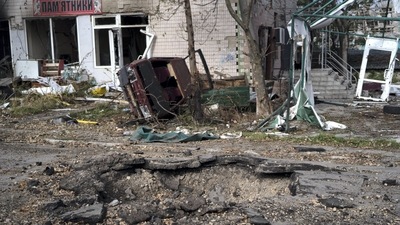 A destroyed car is seen in front of a crater created by an explosion on a street in the retaken village of Velyka Oleksandrivka, Ukraine, (AP) A destroyed car is seen in front of a crater created by an explosion on a street in the retaken village of Velyka Oleksandrivka, Ukraine, (AP)