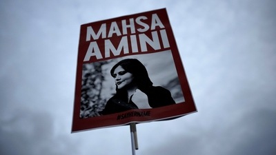 Iran Anti-Hijab Protests: A woman holds a placard with a picture of Iranian woman Mahsa Amini during a protest against her death. (AP) Iran Anti-Hijab Protests: A woman holds a placard with a picture of Iranian woman Mahsa Amini during a protest against her death. (AP)