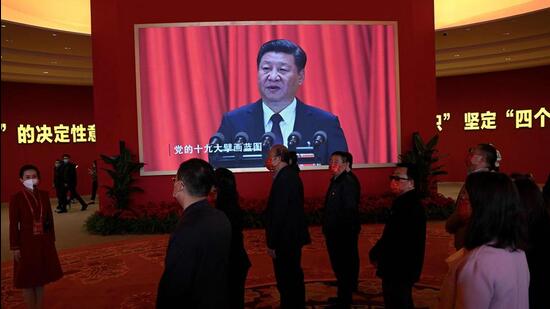 Visitors stand in front of a screen showing Chinese President Xi Jinping during the exhibition entitled ‘Forging Ahead in the New Era’, showing the country’s achievements during his past two terms, at the Beijing Exhibition Center in Beijing on Tuesday. (AFP)