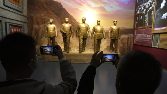 Visitors to the Museum of the Communist Party of China take photos of statues depicting former Chinese leaders in Beijing.(AP)