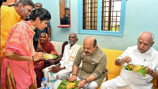 Chief minister Basavaraj Bommai has breakfast with Hirala Kollarappa, a Dalit community member, and his family members, at Kamalapura village in Vijayanagar district. (PTI)