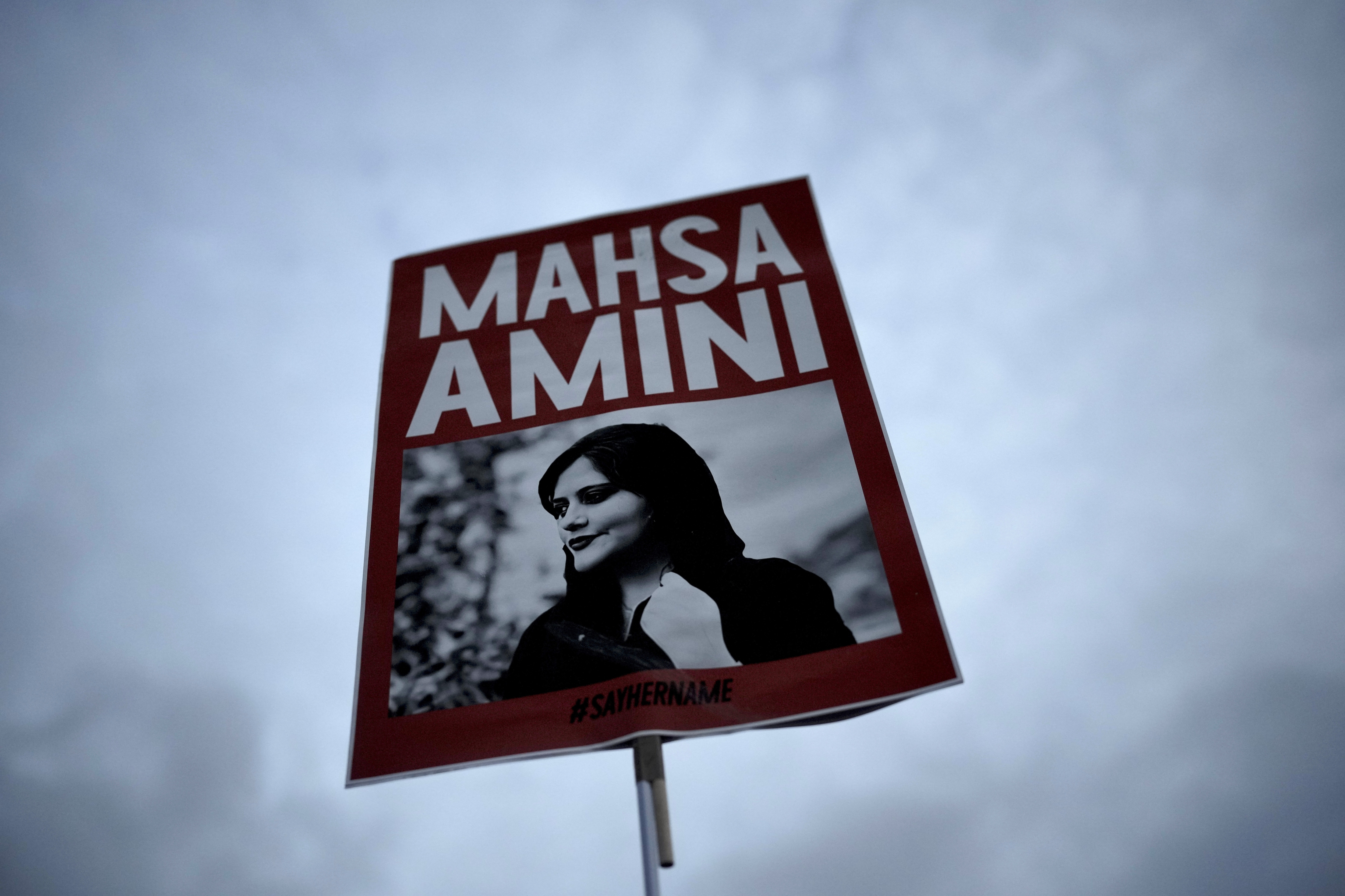 Iran Anti-Hijab Protests: A woman holds a placard with a picture of Iranian woman Mahsa Amini during a protest against her death.&nbsp; (AP)