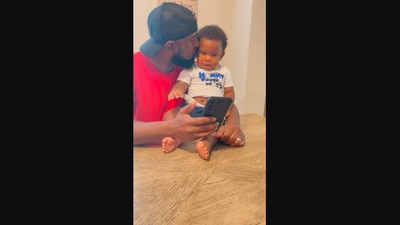 The image, taken from the Instagram video, shows the little boy watching a video of him and his dad. (Instagram/@authentically_aja)