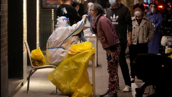 A medical worker in a protective suit collects a swab from a resident for nucleic acid testing, following the coronavirus disease (COVID-19) outbreak in Shanghai, China.(REUTERS)