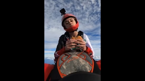 The woman can be seen eating a burger while skydiving.&nbsp;(Instagram/@mckennaknipe)