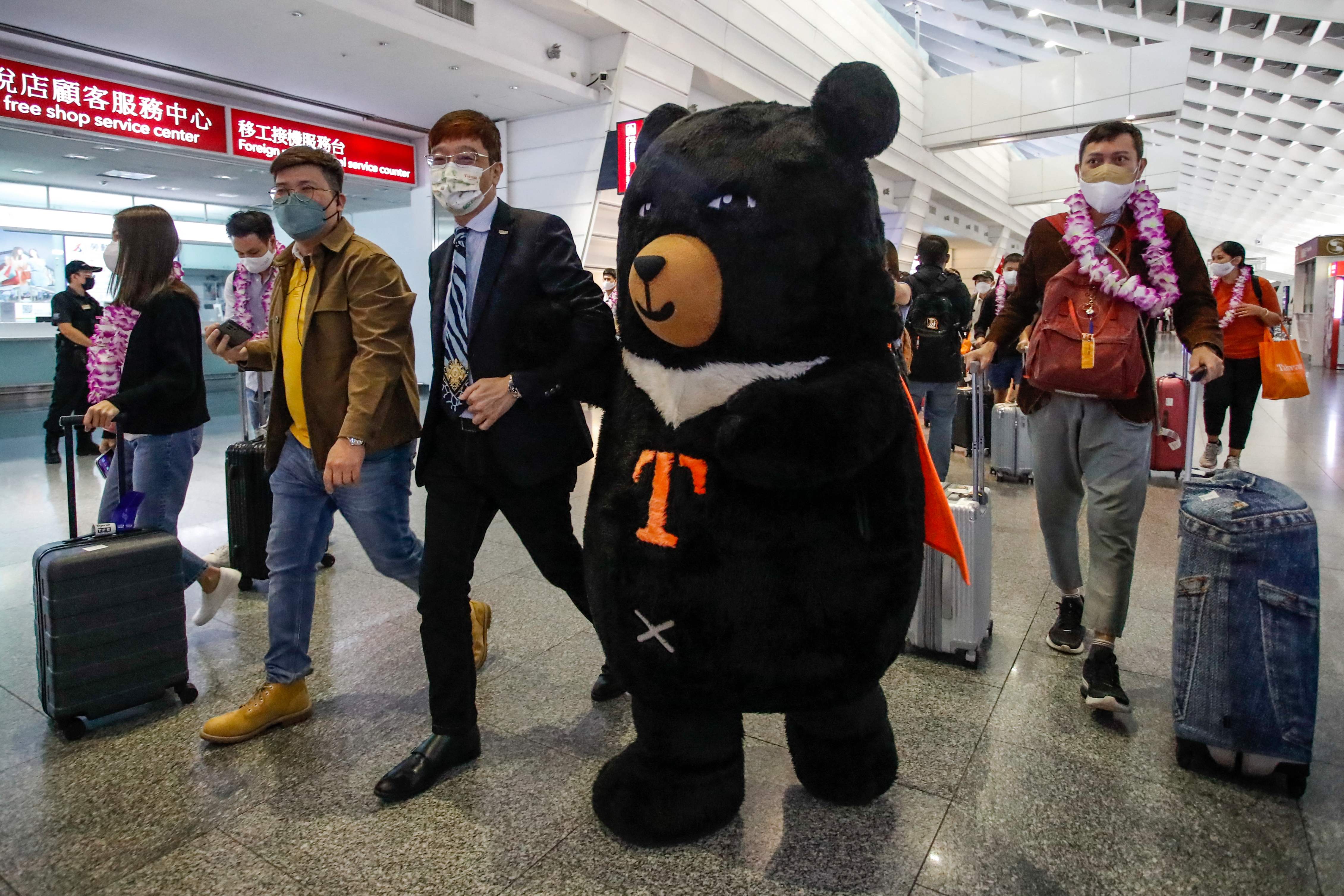 A mascot and an official (centre L) welcome a group of passengers from Thailand at Taoyuan International Airport in Taoyuan on October 13, 2022, after Taiwan reopened its borders by ending mandatory Covid quarantine for arrivals. (Photo by Daniel CENG / AFP) (AFP) A mascot and an official (centre L) welcome a group of passengers from Thailand at Taoyuan International Airport in Taoyuan on October 13, 2022, after Taiwan reopened its borders by ending mandatory Covid quarantine for arrivals. (Photo by Daniel CENG / AFP) (AFP)