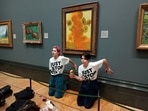 Activists of "Just Stop Oil" glue their hands to the wall after throwing soup at Van Gogh's ‘Sunflowers’ at the National Gallery in London,&nbsp;