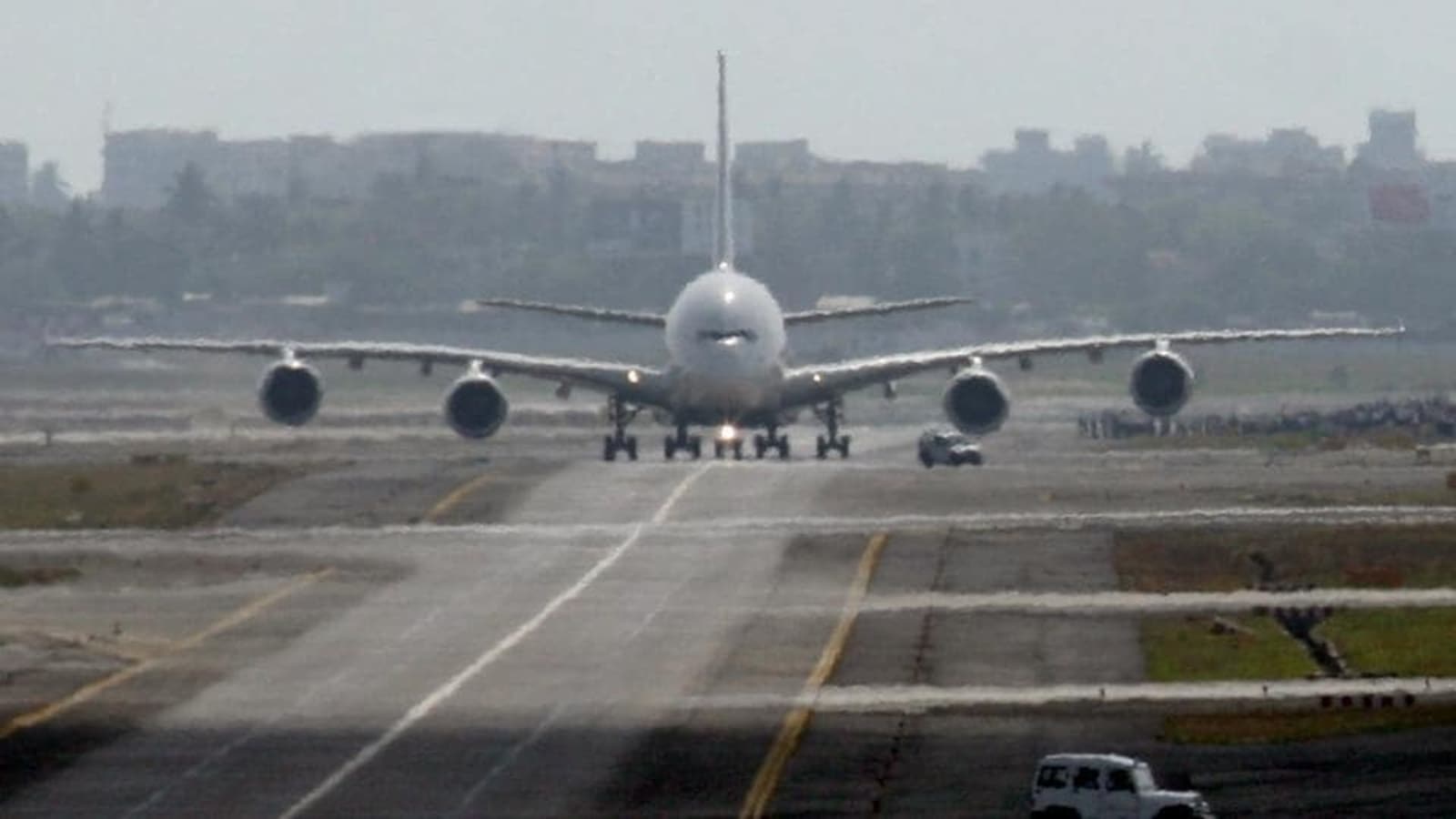 Passengers wait next to a giant suitcase outside the terminal building of  Bengaluru International Airport at its opening in Devanahalli, on the  outskirts of Bangalore, India, Friday, May 23, 2008. The Bengaluru