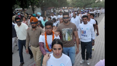 Visually impaired students leading sighted people during a walk, organised to encourage eye donation, at the Sector-17 Plaza in Chandigarh on Friday. (Ravi Kumar/HT)