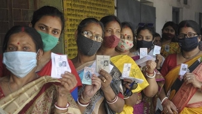 Women show their voter ID cards as they stand in a queue to cast their vote at a polling station. (PTI file.) Women show their voter ID cards as they stand in a queue to cast their vote at a polling station. (PTI file.)
