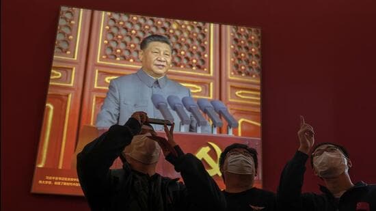 Visitors wearing face masks stand watch in front of a screen showing Chinese President Xi Jinping at an exhibition highlighting Xi and China's achievements under his leadership at the Beijing Exhibition Hall in the capital city where the 20th Party Congress will be held in Beijing. (AP)