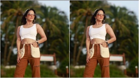 सनी एक सफेद क्रॉप्ड टैंक टॉप में कमर पर एक गाँठ के साथ सजाए गए, और इसे कई जेब और चौड़े पैरों के साथ मैरून पतलून की एक जोड़ी के साथ जोड़ा।(Instagram/@sunnyleone)