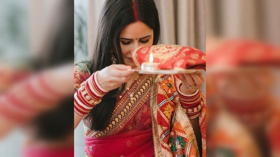 Katrina Kaif wore a beautiful red saree with a contrasting pastel green blouse while Vicky Kaushal complemented his wife in a beige kurta pyjama.(Instagram/@katrinakaif)