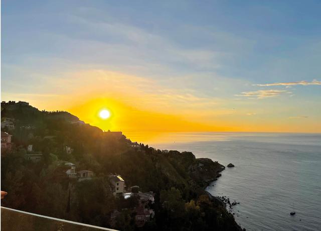 The sunrise in Sicily, which has a blue sea from which the hot, yellow sun, looking a little like a ball of lava itself, rises every morning