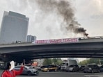 China Protests: Smoke rises as a banner with a protest message hangs off Sitong Bridge, Beijing, China.