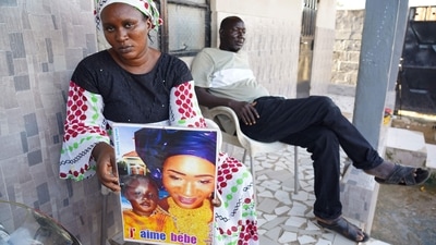 Mariama Kuyateh, 30, holds up a picture of her late son Musawho died from acute kidney failure, in Banjul, (AFP) Mariama Kuyateh, 30, holds up a picture of her late son Musawho died from acute kidney failure, in Banjul, (AFP)